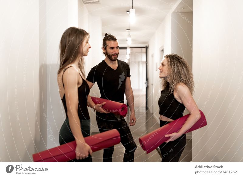 Junge Freunde kommunizieren im Yoga-Unterricht Training Atelier Stehen reden Unterlage bereit Zusammensein Pause Sportbekleidung Mann Frauen Fitness Übung