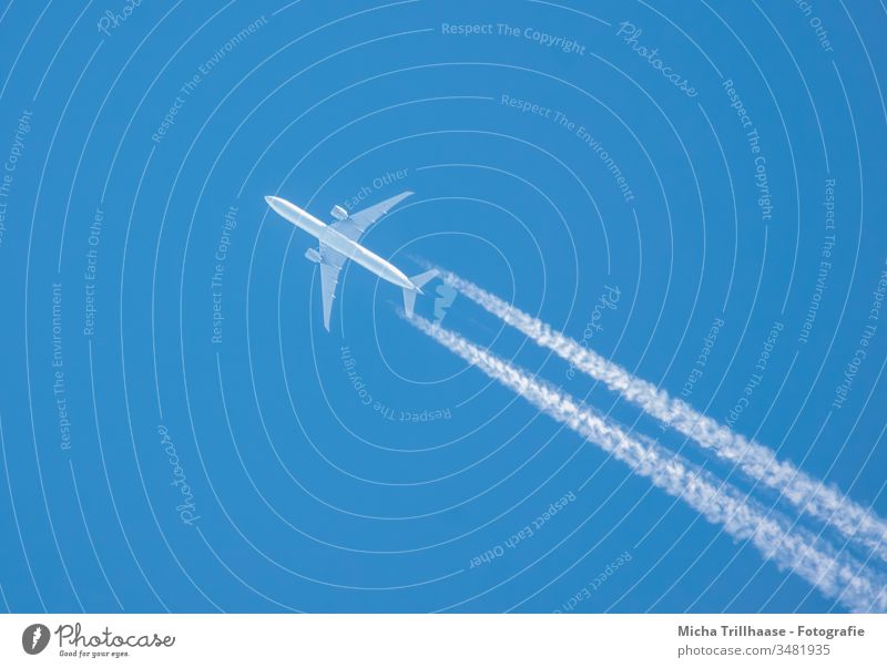Flugzeug und Kondensstreifen am blauen Himmel Tragflächen Triebwerke Flugreise reisen Tourismus Touristen Fernreisen Umwelt Klima Urlaub Ferien Urlaubsreise
