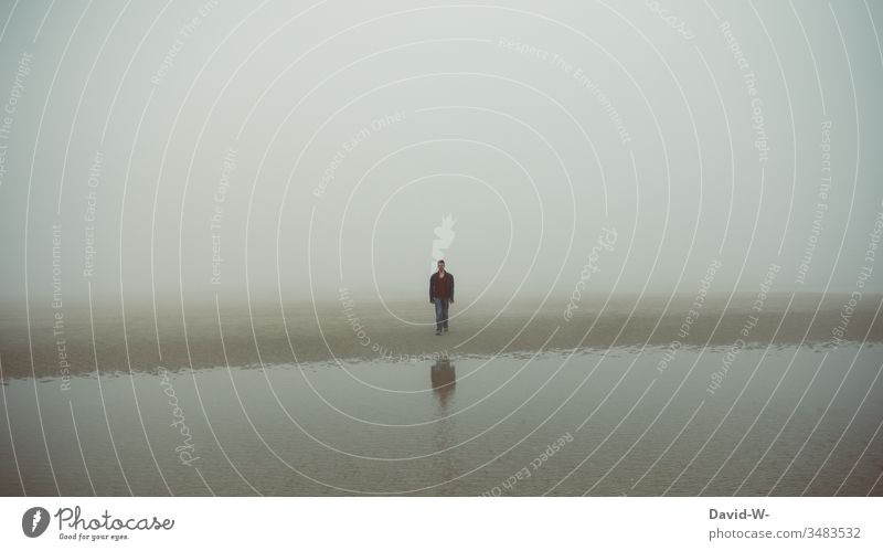 Mann in der Ferne - irgendwo im nirgendwo Mensch verlassen einsam Einsamkeit Abstand ruhe Düster weite Nebel Nebelschleier Spiegelbild Spiegelung Wasser See