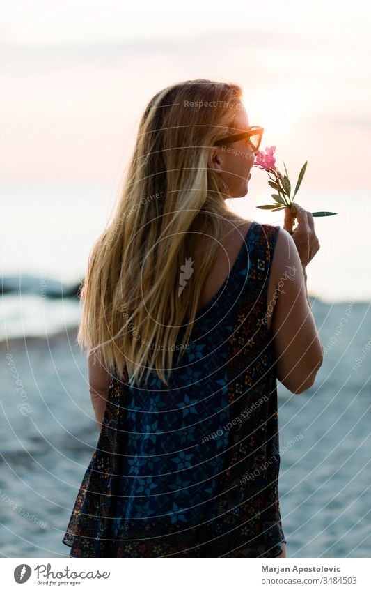 Junge Frau genießt Sonnenuntergang am Strand Erwachsener schön Schönheit sorgenfrei Abenddämmerung Genuss exotisch Blume Freiheit Spaß Mädchen Fröhlichkeit