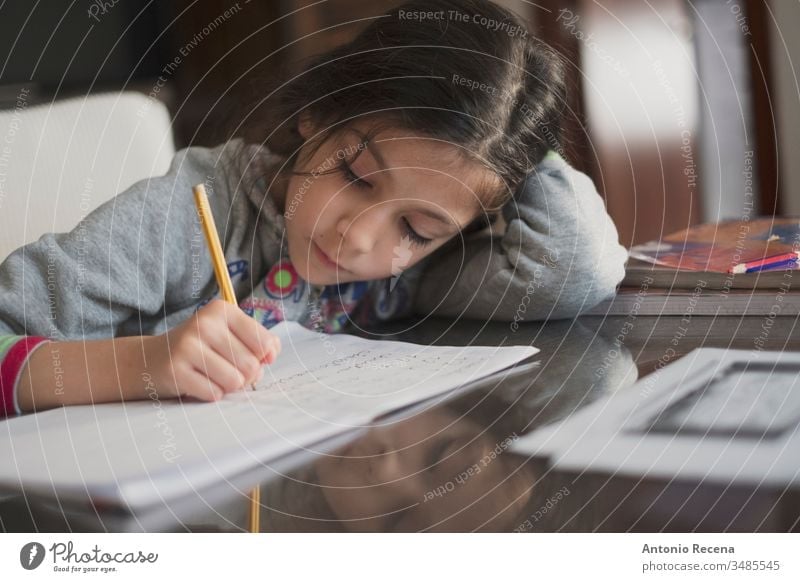 Siebenjähriges Mädchen macht zu Hause Hausaufgaben Bildung Schüler schreibend heimwärts 7s Sitzen Menschen Person Kind Bleistift Kindheit Kinder offen