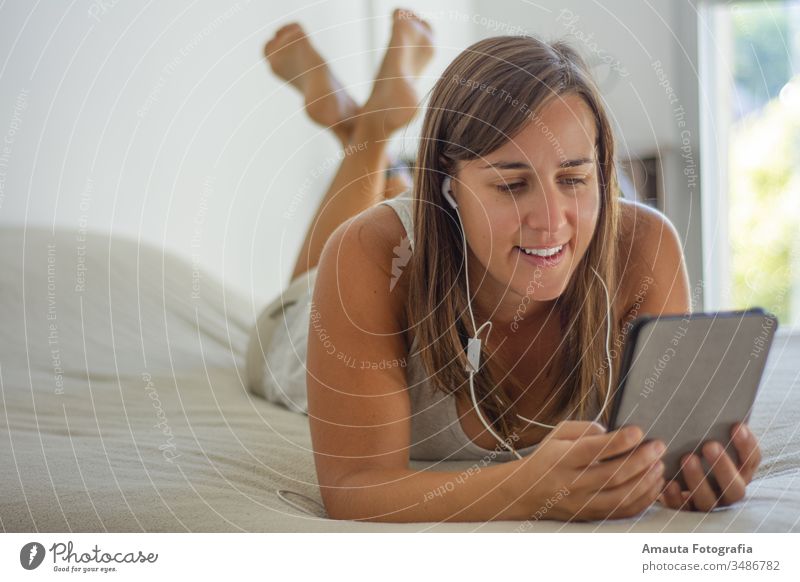 Frau mit einem Videoanruf am Bett Erwachsener App Knospen Anruf Funktelefon Talkrunde plaudernd Bekleidung Corona-Virus Bund 19 digitales Buch Entfernung