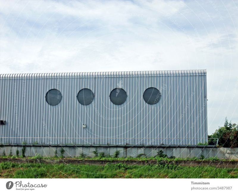 Die Schönheit im Auge des Betrachters | Fassade Gebäude Architektur Gewerbebau Linien Metall Fenster rund Beton Gras Himmel Wolken zweckmäßig