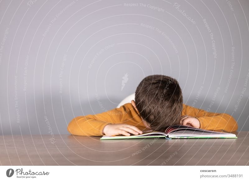 Verärgerter Schuljunge mit Lernschwierigkeiten wütend blau Buch Junge Kaukasier Kind Klasse Klassenraum niedlich niedergeschlagen Schreibtisch Schwierigkeit