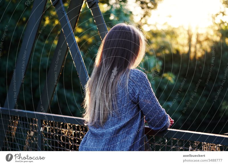 junge Frau steht allein am Brückengeländer Junge Frau Einsamkeit Depression Zukunftsangst Rückansicht unkenntlich Aussicht Geländer stehen anlehnen Natur