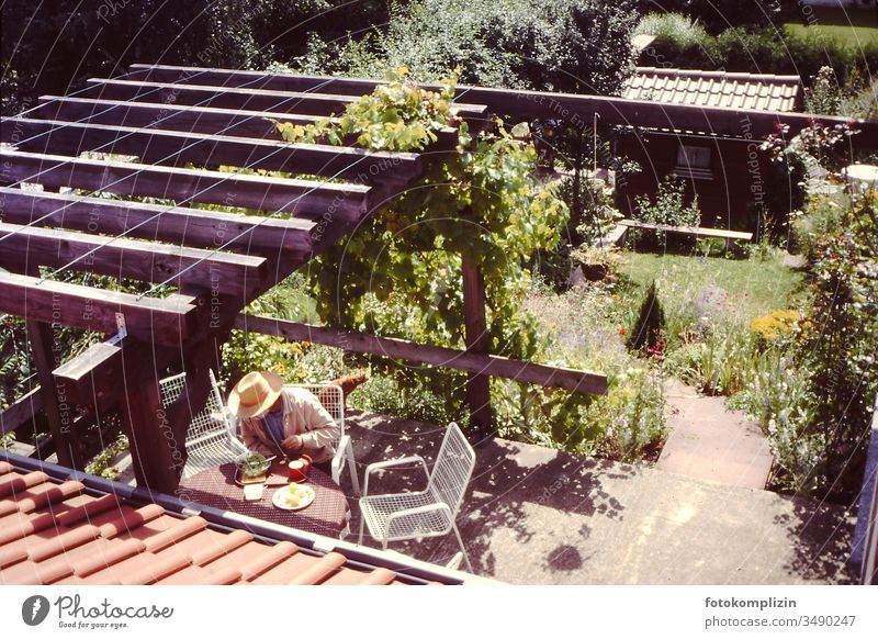 Mann beim Essen auf Terrasse mit Blick von oben Terasse Single allein Witwer Gartenleben Einsamkeit einzeln Mensch einsam terrasse Laube mittagessen Hütte