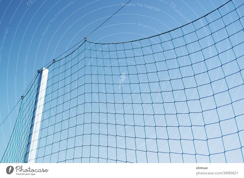 grobmaschiges Netz mit Aufhängung am Spielfeldrand vor blauem Himmel durchhängen Abgrenzung schräg Schutz Spielnetz im Freien Spielplatz Spielen Sport