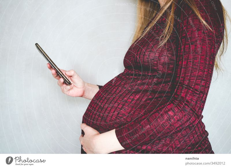 Junge schwangere Frau sucht Informationen mit ihrem Smartphone Schwangerschaft Fragen suchen Internet soziale Netzwerke WiFi Technik & Technologie Mama Mutter