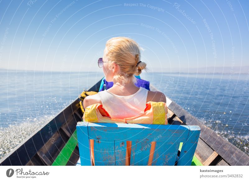 Weibliche Touristen reisen mit traditionellen Booten. Wasser Frau See Rückseite Urlaub Transport MEER Himmel Reise Leben Natur im Freien Sicherheit Freizeit
