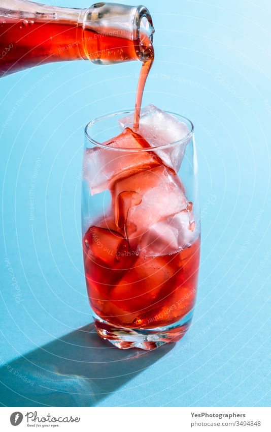 Übergießen mit Erdbeersirup in einem Glas Wasser. Getränk blau hell Nahaufnahme Cocktail Erfrischungsgetränk farbenfroh Textfreiraum kristallklar lecker Entzug