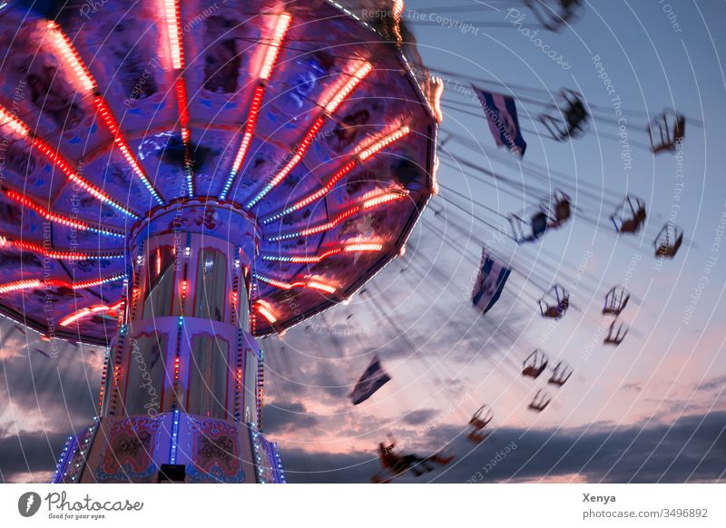 Karusell bei Nacht Bewegung Freude Jahrmarkt Fahrgeschäfte fliegen drehen blau rote Lichter Wellenflug Kettenkarusell Schwungvoll Oktoberfest Freizeit & Hobby