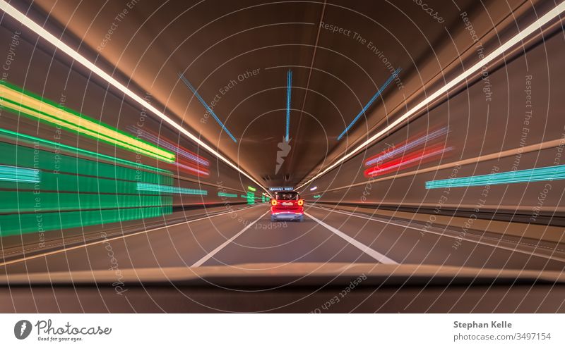 Schnell fahrender Wagen durch einen Tunnel mit verschwommenen Lichteffekten, eine urbane Rennszene mit Führungslinien und Symmetrieaufbau. Stollen