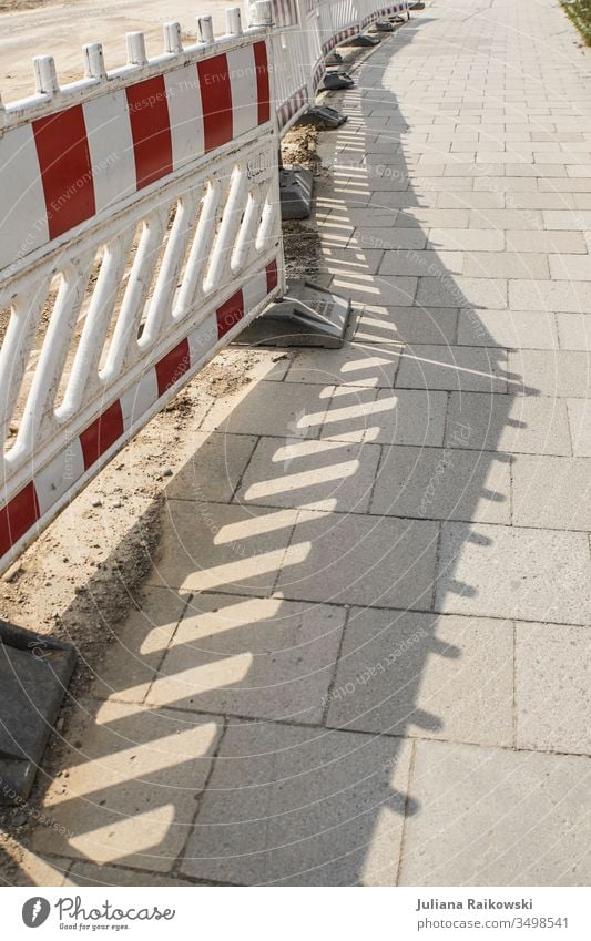 Schatten auf dem Gehweg von einem Bauzaun Absperrung Sicherheit Schutz Barriere Zaun Baustelle Strukturen & Formen Verbote Außenaufnahme Linie Menschenleer