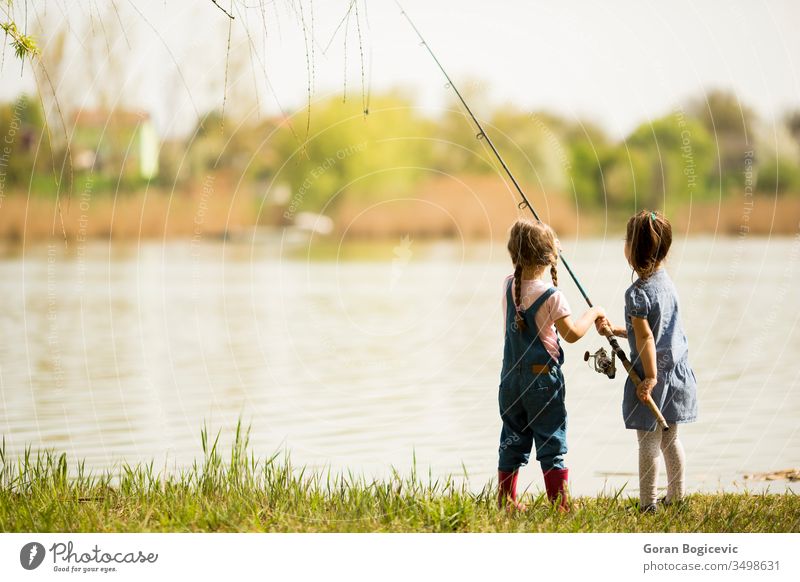 Zwei kleine Mädchen beim Angeln Aktivität fangen Kaukasier Kind Kindheit niedlich Genuss Frau Fisch Fischer Fischen Spaß Fröhlichkeit Glück Halt Freude See