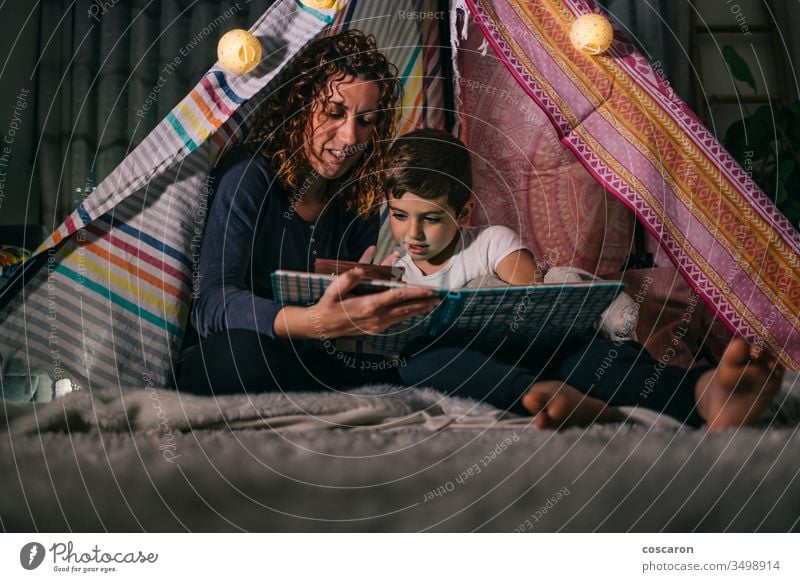 Mutter und Sohn lesen zu Hause auf einem Zelt ein Buch schön Schlafzimmer Schlafenszeit Kaukasier Kind Kindheit Konzept niedlich dunkel Tochter Tag Bildung