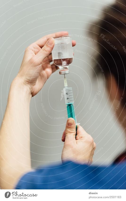 Gesundheits- und Krankenpflegerin zieht 0,9 prozentige Natriumchlorid-Lösung in eine 10ml Spritze auf Gesundheitswesen Medikament Impfstoff Behandlung Krankheit