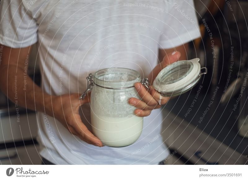 Ein Mann hält ein Einmachglas mit selbstgemachtem Kefir in der Hand Proteine Milchprodukte Eiweiß Ernährung halten lecker Küche gesund Hände Person Mensch
