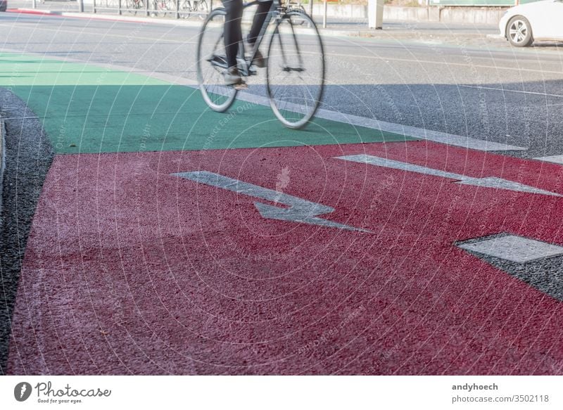 Fahrradweg mit einem Übergang von Grün zu Rot mit einem Radfahrer Aktion aktiv Aktivität Pfeil Asphalt Berlin Biker Radfahren Großstadt Zyklus Regie Übung
