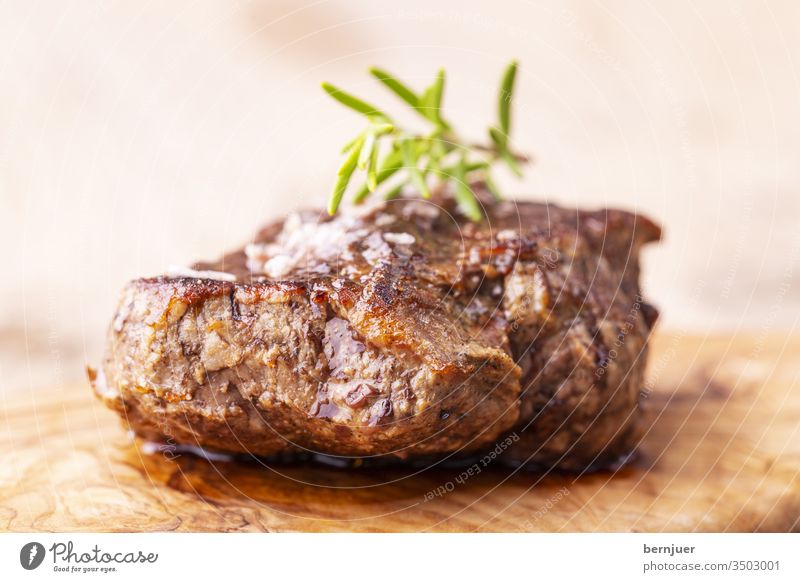 gegrilltes saftiges Steak auf Olivenholz Fleisch Rindersteak Rindfleisch Rosmarin Barbecue schwarz tenderloin Gebraten Filet Abendessen Mahlzeit Grillen Essen
