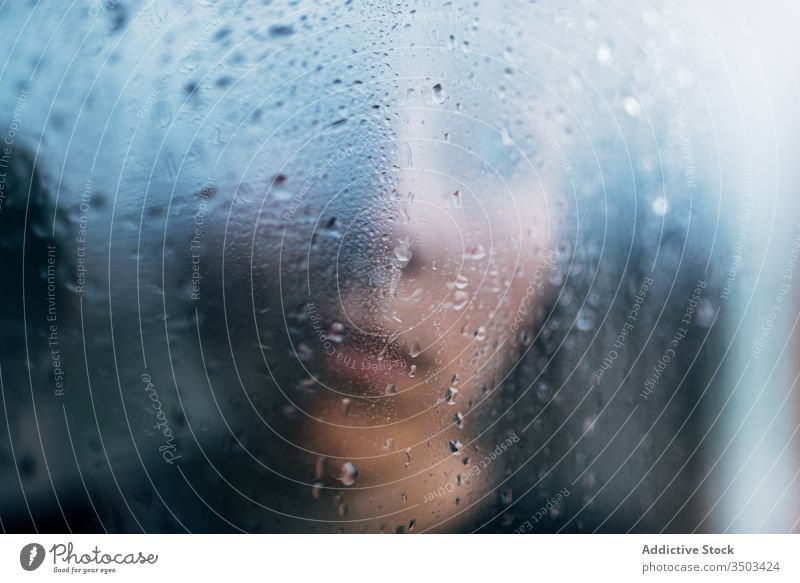 Nicht erkennbare Person hinter nassem Glas stehend traurig Depression Isolation Melancholie Einsamkeit unglücklich Stress verärgert einsam Regen Coronavirus