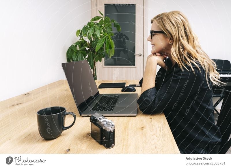 Frau arbeitet von ihrem Atelierbüro zu Hause aus heimwärts Schreibtisch Computer Business Büro Erwachsener Brille Laptop Kaukasier Browsen Tippen arbeiten