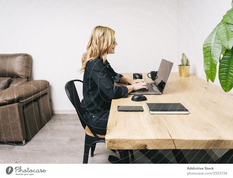 Frau arbeitet von ihrem Atelierbüro zu Hause aus heimwärts Schreibtisch Computer Business Büro Erwachsener Brille Laptop Kaukasier Browsen Tippen arbeiten