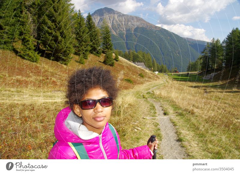 junges Mädchen lächelt glücklich auf Bergpfaden Holz Stöcke Norden Wege Natur schlendern Berge u. Gebirge Himmel blau laufen Schatten Bäume Kurven