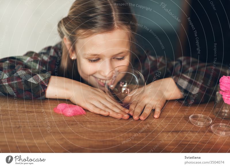 Das Kind hält ein Spielzeug namens Schleim in der Hand, das Kind hat Spaß und experimentiert. Hintergrund weiß Neuheit Entertainment Beteiligung vereinzelt