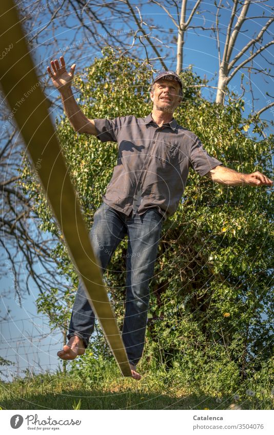 Im Gleichgewicht auf der Slackline Mann Mensch Erwachsene maskulin balanciergang Balance Balanceakt Ganzkörperaufnahme Sommer Tag Zufriedenheit Gras Efeu Baum