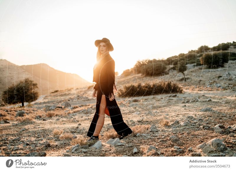 Stilvolle Frau steht auf Fels in der Landschaft Stein Sonnenuntergang Hut Spaziergang Outfit Schleim Model schwarz trendy Natur Felsen Felsbrocken Abend