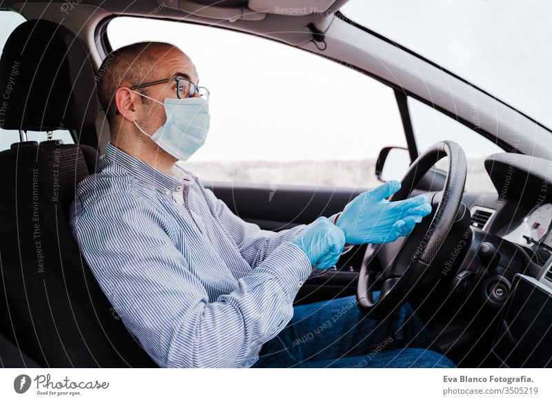 mann im auto mit schutzmaske und handschuhen während der coronacirus-pandemie covid-19 Mann fahren PKW Schutzmaske Coronavirus Pandemie Schutzhandschuhe Virus