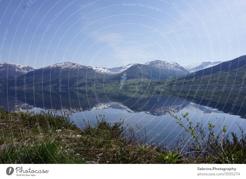 Spiegelung der Natur in den beschneiten Bergen Norwegens an einem sonnigen Tag Norwegische Schönheit. Landschaft Spiegelung im Wasser Berge u. Gebirge Europa