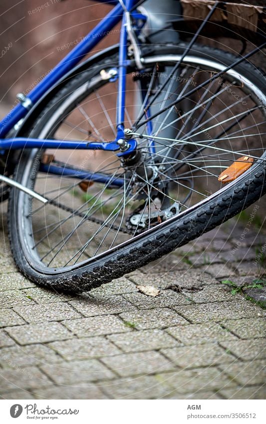 verbogenes Hinterrad eines alten Fahrrads Verlassen Unfall Rücken Hintergrund angewinkelt gebogenes Rad Fahrräder Radfahren schwarz gebrochen anketten Großstadt