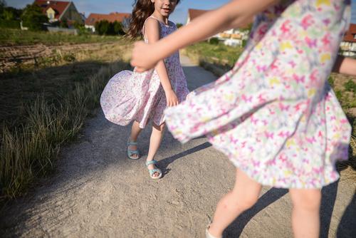 Two sisters play games Außenaufnahme Natur Tag sonne kleid girl summer playtime