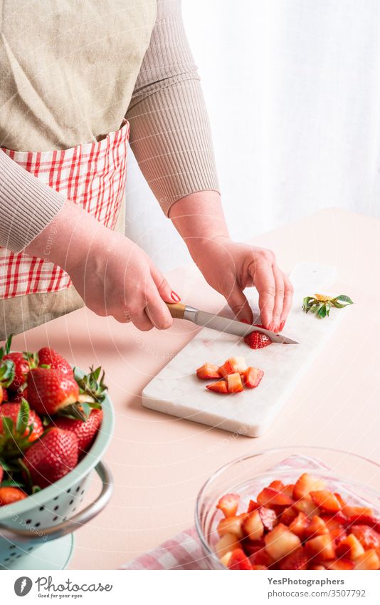 Hausfrau macht Erdbeermarmelade. Frau, die Früchte schneidet Beeren klassisch Essen zubereiten Schneidebrett geschnittene Stücke Schneiden Dessert
