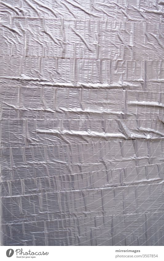 strukturierte Bandwand mit silbernem Entenband bedeckt abstrakt Klebstoff Hintergrund bandagieren Klotz Baustein Nahaufnahme durchkreuzen Kanal Element fixieren