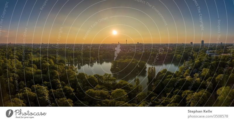 Ein idyllischer Park im Englischen Garten von München mit einem schönen See als Luftbild. Natur Sonnenuntergang Antenne Dröhnen Himmel Bäume grün Sommer Boot