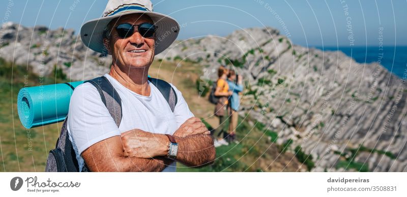 Älterer Mann beim Trekking mit Blick in die Kamera Senior Lächeln in die Kamera schauen Landschaft Wanderung Transparente Kopfball Panorama panoramisch Netz
