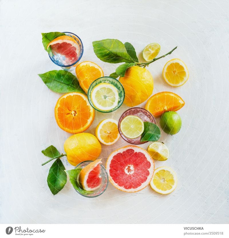 Gruppenzusammensetzung verschiedener organischer Zitrusfrüchte mit grünen Blättern auf weißem Hintergrund, Draufsicht. Gesunde Ernährung.  Inhaltsstoffe. Vitamine. Hälften und Scheiben. Gestaltung