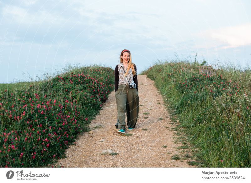 Junge Abenteurerin beim Wandern auf den Feldern der Toskana, Italien Erwachsener Abenteuer Fotokamera lässig heiter Land Landschaft genießend Europa Abend