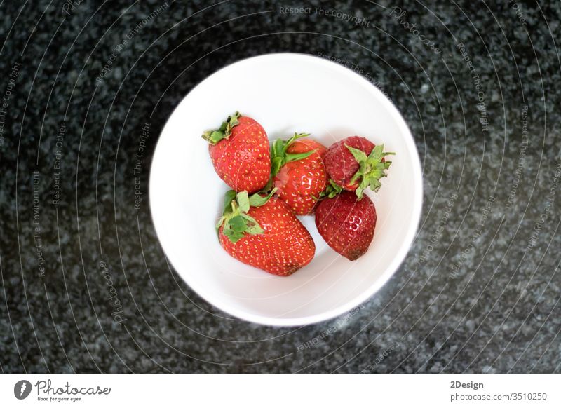 Draufsicht auf Erdbeeren über dunklem Marmor ländlich Nahaufnahme süß saftig Dessert Schalen & Schüsseln Licht weiß dunkel Murmel Vegetarismus frisch