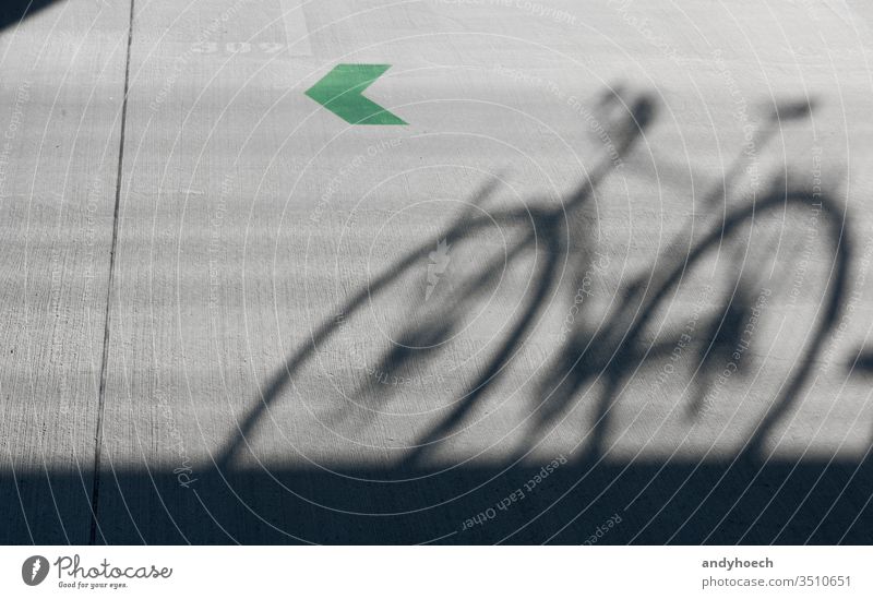 Ein Schatten eines Rennrads mit grünem Pfeil 309 abstrakt Architektur Hintergrund Fahrrad Radfahren schwarz Großstadt Farbe Mitteilung Konzept Beton