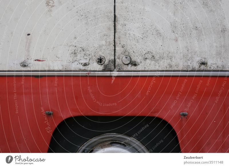Radkasten und Bordwand eines alten Marktwagens rot weiß WAnd Metall Reifen Wagen Wohnwagen Schloss Fugen schmutzig abstrakt