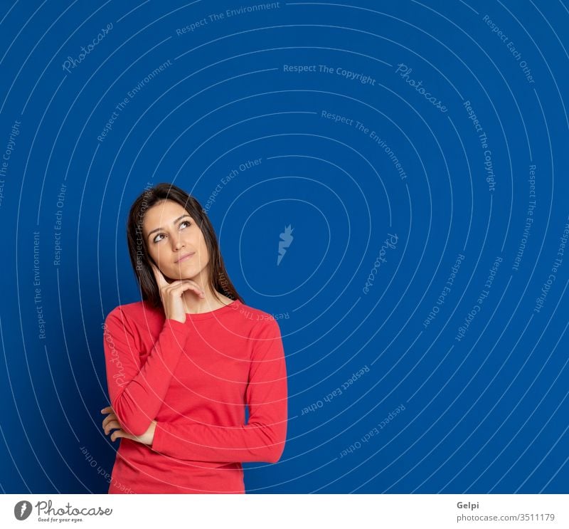 Brünette junge Frau trägt ein rotes T-Shirt Mädchen Person blau nachdenklich Geist Finger besinnlich Denken sich[Dat] einbilden Vorstellungskraft Idee