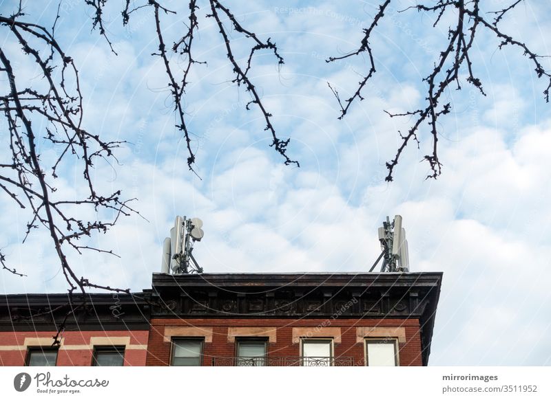 Frühlingsbäume, New Yorker Gebäude mit Mobilfunkmasten auf ihrem Dach an einem sonnigen, kalten Tag Architektur Himmel keine Menschen Gebäudeaußenseite