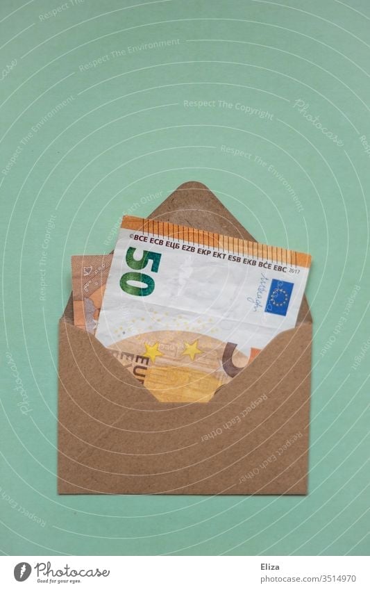 Ein brauner Umschlag in dem ein Geldschein steckt 50er 50 Euro Schein Geschenk schenken Geldgeschenk Rechnung Post Innenaufnahme sparen Menschenleer