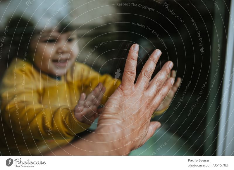Kind berührt Vaterhand durch Glas Quarantäne Quarantänezeit Coronavirus sars Pandemie COVID covid-19 Prävention Seuche ansteckend infektiös