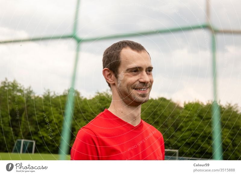 Porträt von Sportler Kopf Fußball Spieler Tor Meister Gras spielen Konkurrenz Gewinner Netz Lächeln sportlich Person Hintergrund jung Ausdruck gutaussehend