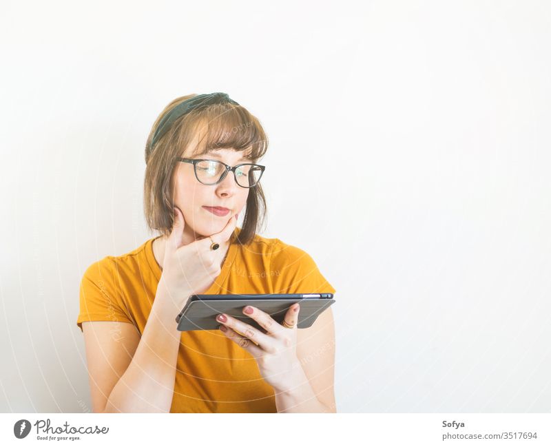 Lächelnde junge Frau in Gelb mit Tablette. online kaufen Person benutzend Mobile Schüler Lifestyle Quarantäne Schule Erwachsener zu Hause bleiben klug niedlich