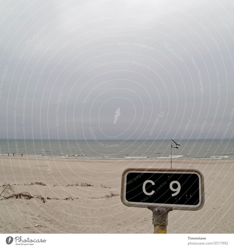 Treffpunkt C 9 beim Fahnenrest Schild Orientierung Schilder & Markierungen Hinweisschild Sand Strand Nordsee Wasser Himmel Wolken trüb Horizont Dänemark